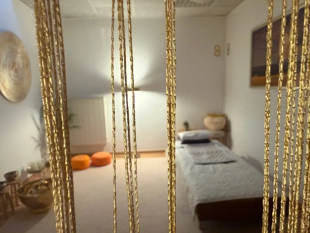 Goldener Perlenvorhang, dahinter ein ruhiges Behandlungszimmer