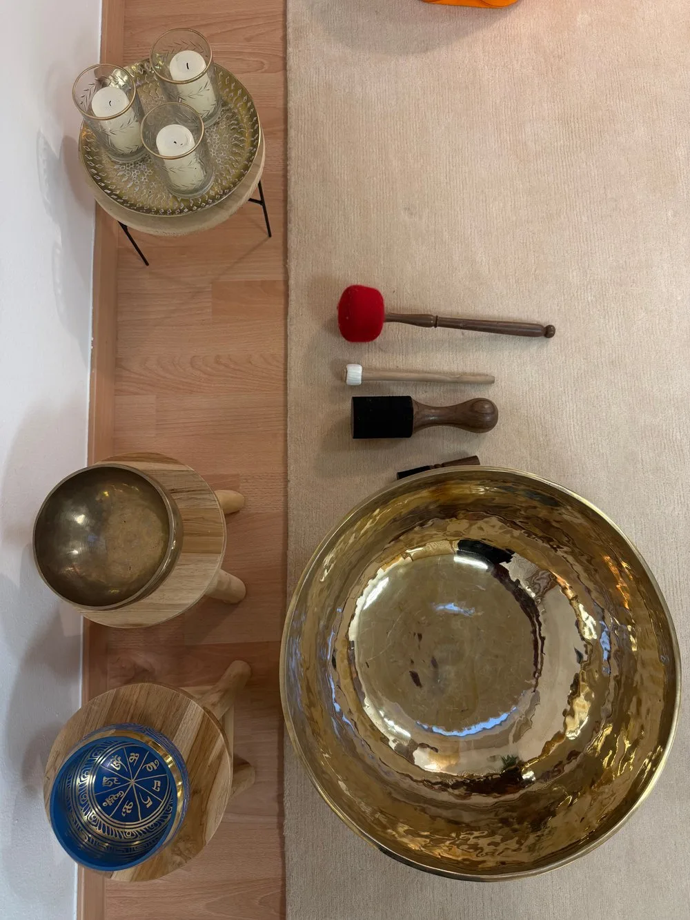 Große goldene Klangschale mit kleineren Schalen und Kerzen